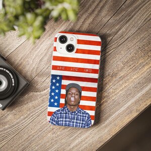 Könnte beinhalten: Eine Handyhülle mit einem rot-weiß-blauen amerikanischen Flaggenmuster. Die Hülle zeigt ein Porträt eines Mannes mit einem schwarz-weiß karierten Hemd und dem Text "LOVE - LOVE - ASAP" auf der Flagge.