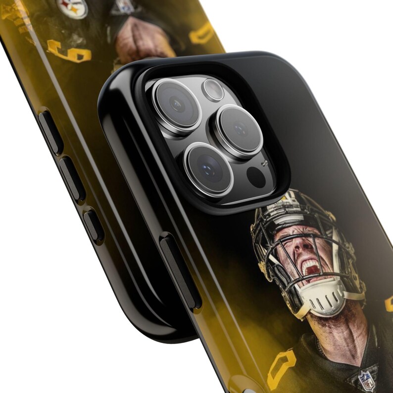 May include: Black phone case featuring a yellow and black image of a football player. The case has a black camera bump with three lenses.