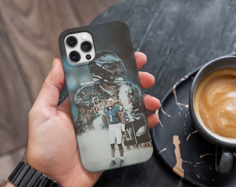 May include: A black phone case featuring a photograph of a football player wearing a green and white jersey with the words "GO BIRDS" on it. The player is holding a football and is surrounded by other players.
