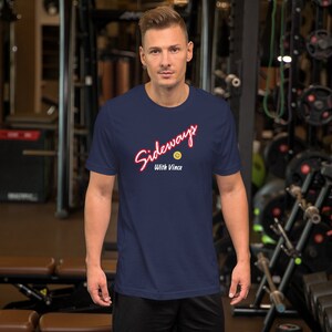May include: A navy blue t-shirt with a white and red graphic that says "Sideways with Vince" and a yellow smiley face.