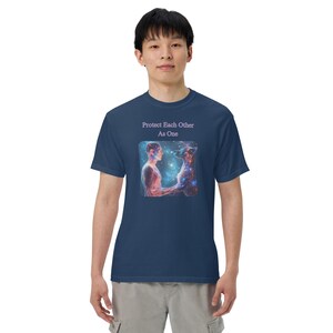 May include: A navy blue t-shirt with a graphic of a man and a dog with a galaxy background. The text "Protect Each Other As One" is printed on the shirt.