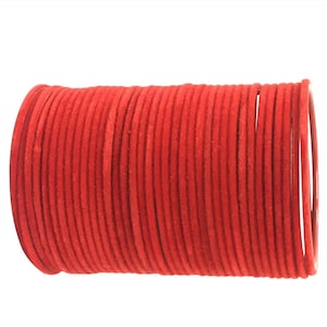 May include: A stack of red velvet bangles. The bangles are made of a soft, velvety material and are perfect for adding a touch of color and style to any outfit.
