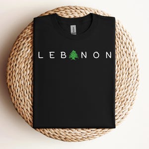 May include: Black t-shirt with white text that reads "LEBANON" and a green cedar tree graphic.