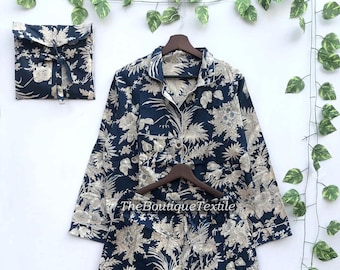 May include: A navy blue pajama set with a white floral print. The set includes a long-sleeved shirt with a button-up collar and matching pants. The text "TheBoutiqueTextile" is visible on the image.
