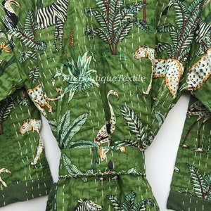 May include: Green cotton robe with a white quilted pattern and a variety of animal and plant prints. The robe has a belt and long sleeves. The prints include zebras, toucans, flamingos, leopards, and palm trees.