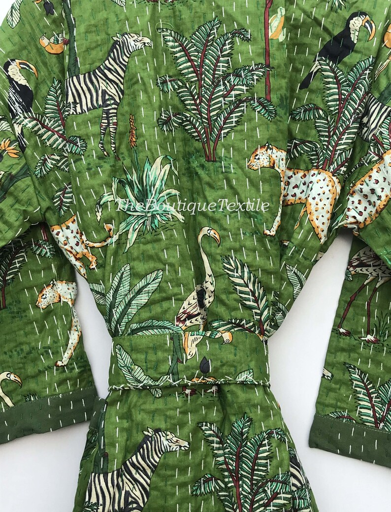 May include: Green cotton robe with a white quilted pattern and a variety of animal and plant prints. The robe has a belt and long sleeves. The prints include zebras, toucans, flamingos, leopards, and palm trees.
