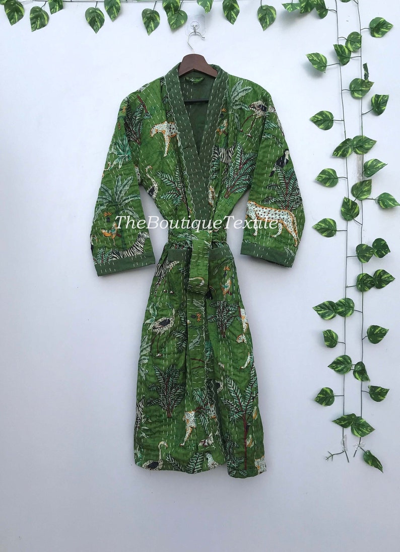 May include: Green quilted robe with a jungle print featuring animals such as zebras, leopards, and birds. The robe has a tie belt and long sleeves.