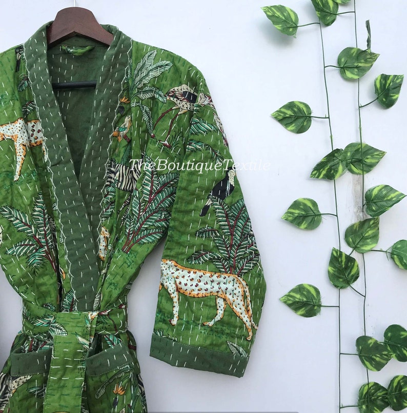May include: Green quilted robe with a jungle print featuring leopards, zebras, birds, and palm trees. The robe has a tie belt and long sleeves.