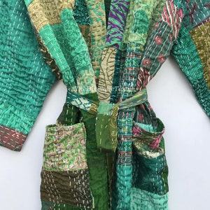 May include: A green patchwork robe with a tie belt. The robe is made of different fabrics and has a quilted design. The robe has pockets on the front.