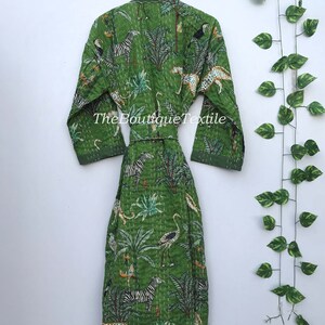 May include: A green cotton robe with a white and black animal print. The robe has a tie belt and long sleeves. The text "TheBoutiqueTextile" is printed on the robe.