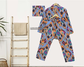 May include: A blue and orange patterned pajama set with a matching pouch. The set features a long-sleeved shirt and pants with a geometric design.