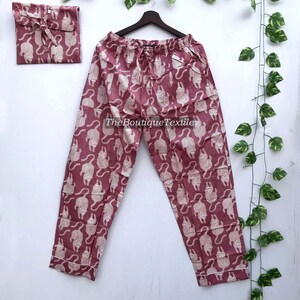 May include: A pair of pink pajama pants with a white animal print. The pants have a drawstring waist and a relaxed fit.