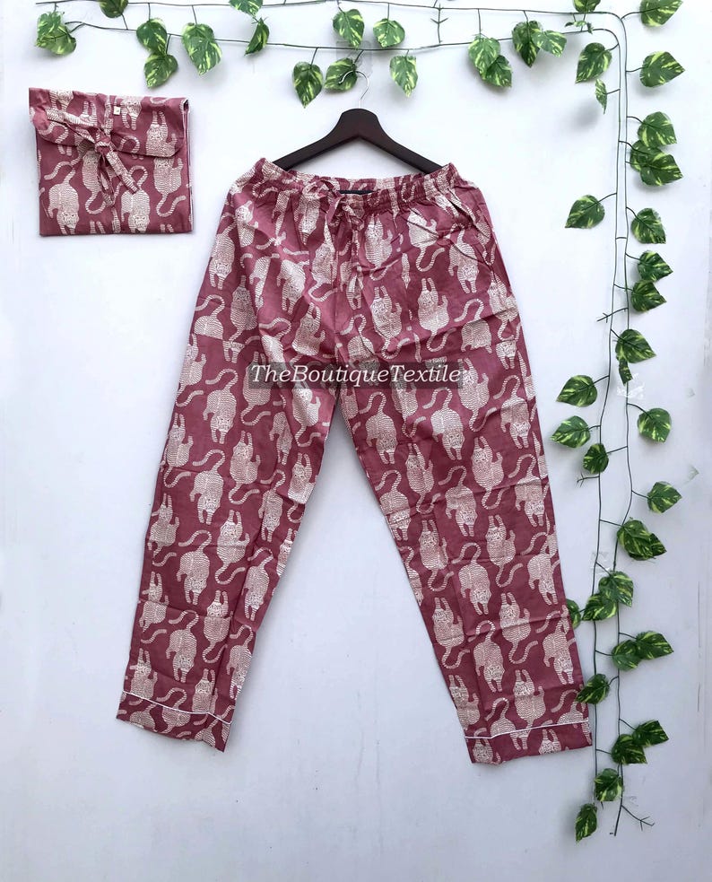 May include: A pair of pink pajama pants with a white animal print. The pants have a drawstring waist and a relaxed fit.