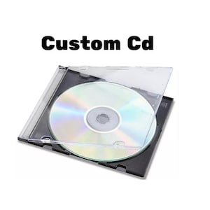 Könnte beinhalten: Eine transparente CD-Hülle mit teilweise geöffnetem Deckel, die eine reflektierende CD zeigt. Der Text "Custom Cd" ist in fetten schwarzen Buchstaben über der Hülle dargestellt. Die CD hat eine silberne und schillernde Oberfläche.