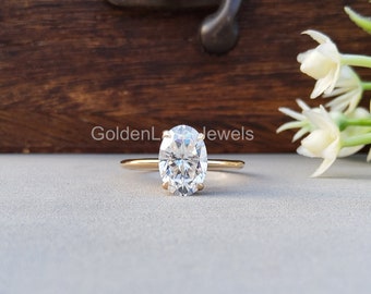 May include: A gold band engagement ring with a large oval-shaped diamond.