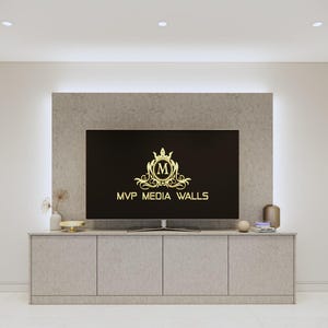 May include: A modern living room with a flat screen TV mounted on a wall with a light grey stone finish. The TV is displaying a logo with the text "MVP MEDIA WALLS". The TV is sitting on a light grey cabinet with three drawers.