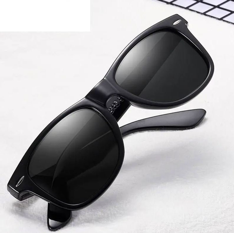 May include: Black sunglasses with a classic rectangular frame and dark lenses.
