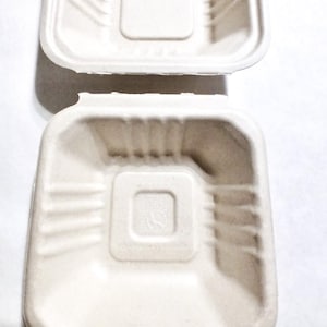 May include: Two white, square, cardboard food containers with a textured surface. The containers are stacked on top of each other. The text "Separating boxes will give you twice as many." is printed below the containers.
