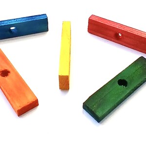 May include: Five colorful wooden blocks in blue, orange, red, green, and yellow. Each rectangular block has a hole in the center. The blocks are arranged on a white background.