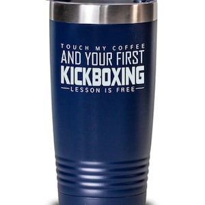 May include: A navy blue stainless steel tumbler with a silver lid. The tumbler has the text "Touch my coffee and your first kickboxing lesson is free" printed on it.