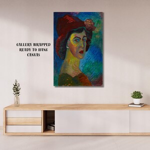 May include: A gallery-wrapped canvas print of a portrait of a woman wearing a red hat with a flower. The artwork features a colorful, impressionistic style with blue, green, and yellow hues. The text "GALLERY WRAPPED READY TO HANG CANVAS" is visible.