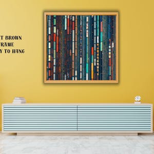 May include: Abstract art print in a light brown frame, ready to hang. The artwork features vertical rectangular shapes in various colors, including blue, orange, and white. The print is displayed on a yellow wall above a light blue cabinet.