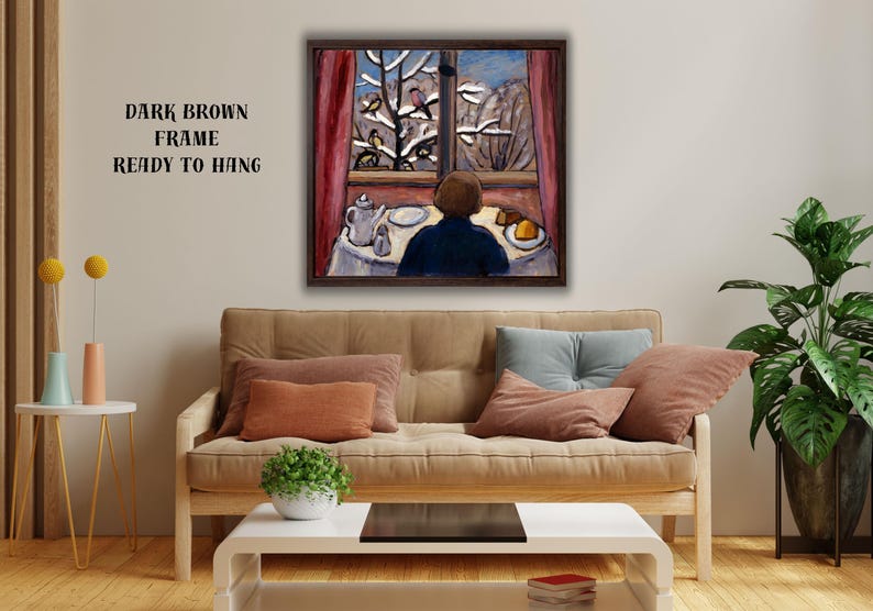 May include: A framed painting depicts a person gazing out a window at a snowy landscape with birds. The artwork features a dark brown frame and is ready to hang. The scene includes a table set with a teapot and plate.