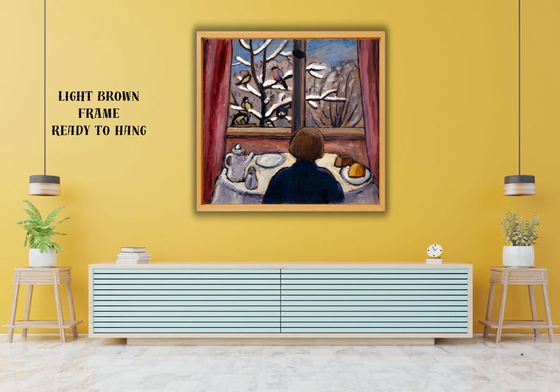 May include: A framed painting depicts a person gazing out a window at a snowy landscape with birds. The scene includes a table set with a teapot, plate, and food. The frame is light brown, and the text "LIGHT BROWN FRAME READY TO HANG" is on the wall.
