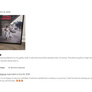 The image is a framed photograph of two people walking on a street, with a sign that reads "COLORED EXTRANGE" above them. The photograph appears to be a high-resolution image of Gordon Parks' work.