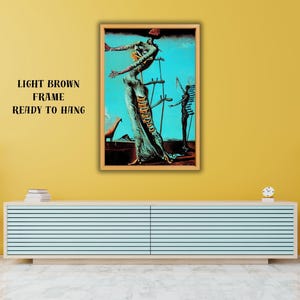 May include: A framed surrealist art print with a light brown frame. The artwork features a figure with outstretched arms, set against a turquoise background. The text "LIGHT BROWN FRAME READY TO HANG" is above the frame.