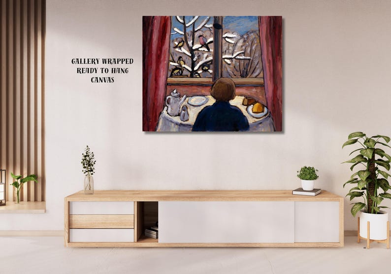 May include: A gallery-wrapped canvas print of an interior scene. A person in a blue shirt sits at a table set with a teapot and cake, looking out a window at a snowy landscape. Red curtains frame the window.