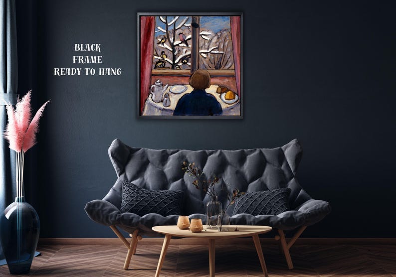 May include: A framed painting depicts a person gazing out a window at a snowy landscape. The artwork features a table set with a teapot, plate, and food. The text "BLACK FRAME READY TO HANG" is visible.