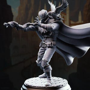 May include: A detailed grayscale figurine of a character in a dynamic pose, wearing a mask, cape, and belt with pouches. An avian figure rests on the character's shoulder. The figure is standing on a circular base with a textured surface.