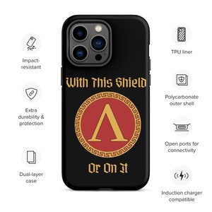 Puede incluir: Una funda de teléfono negra con un diseño de escudo rojo y dorado. El escudo tiene una letra griega A en el centro. El texto "With This Shield Or On It" está impreso en la funda.