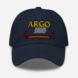 May include: A navy blue baseball cap with an embroidered design of a ship with the word "ARGO" in yellow lettering.