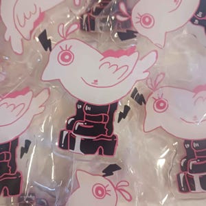 May include: White bird-shaped stickers with pink accents, including wings, eyes, and a small crest. The birds are perched on black boots with lightning bolt details. The stickers are packaged in clear plastic.