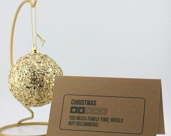 Puede incluir: Una tarjeta marrón con el texto "CHRISTMAS" y una calificación de dos estrellas. El texto debajo de la calificación dice "TOO MUCH FAMILY TIME, WOULD NOT RECOMMEND."