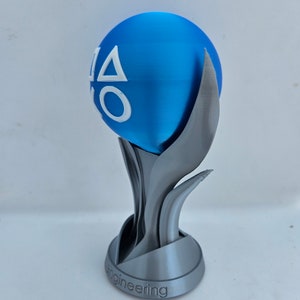 May include: A silver trophy with a blue sphere on top. The sphere has the PlayStation logo on it. The base of the trophy says "engineering".