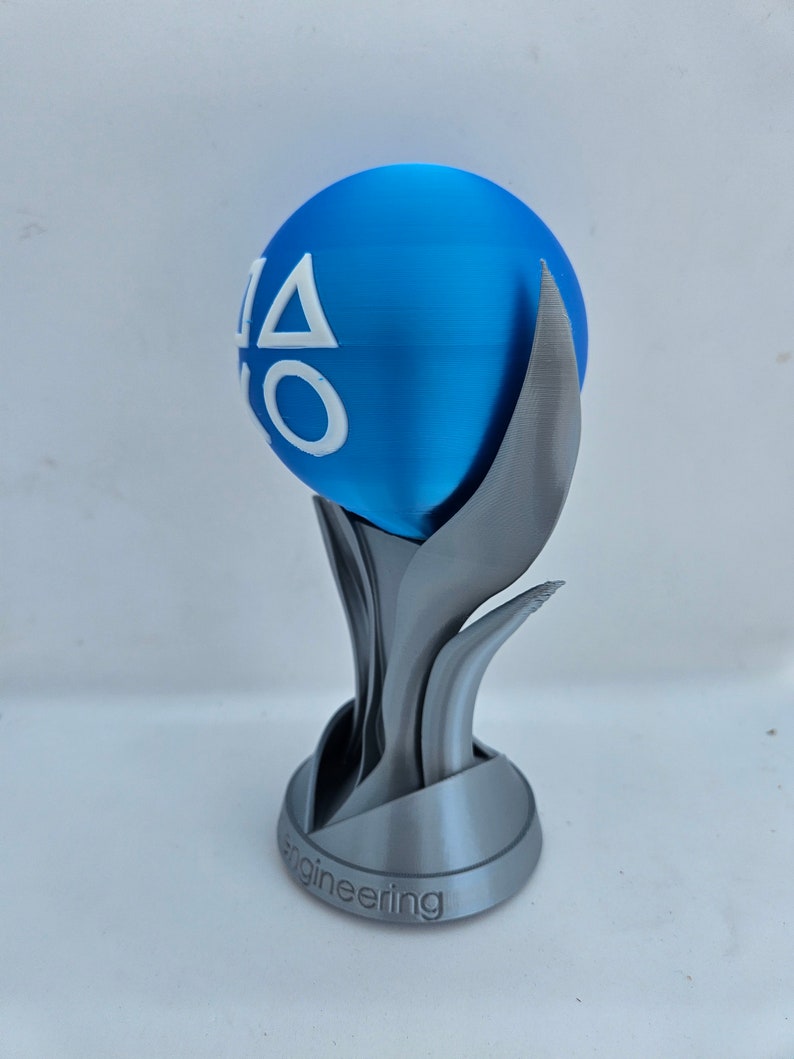 May include: A silver trophy with a blue sphere on top. The sphere has the PlayStation logo on it. The base of the trophy says "engineering".