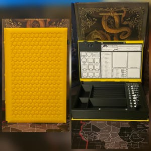 May include: A yellow book-shaped storage box with a textured scale pattern on the cover. The interior features a black organiser with a Dungeons & Dragons character sheet display, including sections for spell slots, stats, and equipment tracking.