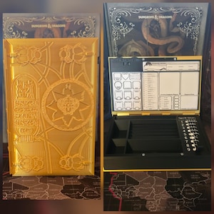 May include: A gold-coloured Dungeons & Dragons game organiser box with an Egyptian-themed relief on the lid featuring scarabs and hieroglyphs. The interior includes a character sheet holder, a dice tray, and a spell slot tracker with numbers 1 through 9.