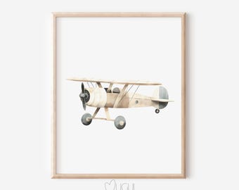 Op de afbeelding: Een aquarel van een beige dubbeldekker met blauwe accenten. Het vliegtuig vliegt in de lucht. Het schilderij is ingelijst in een licht houten lijst.