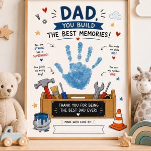 Peut inclure: Une affiche encadrée avec le texte DAD, YOU BUILD THE BEST MEMORIES!, une empreinte de main bleue, des illustrations d'outils dans une caisse en bois, et le texte THANK YOU FOR BEING THE BEST DAD EVER! et MADE WITH LOVE BY: avec une ligne vide.