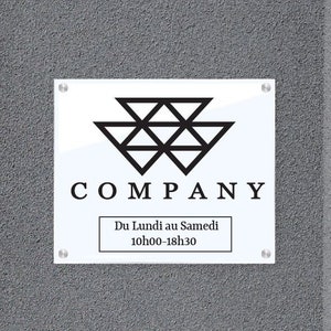 May include: A white sign with a black geometric logo and the word "COMPANY" in black text. The sign also includes the text "Du Lundi au Samedi 10h00-18h30" in black text.