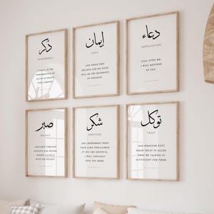 May include: Six framed art prints with Arabic calligraphy and English translations. The prints are in a minimalist style, with black text on a white background, framed in light wood. The themes include remembrance, faith, supplication, patience, gratitude, and trust.