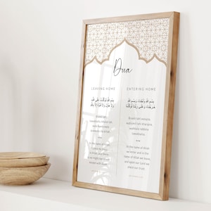 K&ouml;nnte beinhalten: Ein gerahmter Druck mit beigefarbenem Hintergrund und goldenen Akzenten. Der Druck zeigt arabischen Text und englische &Uuml;bersetzungen islamischer Gebete zum Verlassen und Betreten des Hauses. Der Titel "Dua" ist in einer dekorativen Schriftart geschrieben.