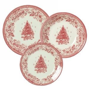 Puede incluir: Un juego de tres platos de cerámica con un centro color crema que presenta una ilustración roja de un árbol de Navidad decorado y estrellas. Los bordes anchos tienen un patrón floral rojo detallado sobre fondo crema.