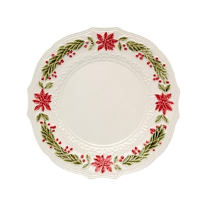 Op de afbeelding: Een witte keramische plaat met een geschulpte rand, versierd met een krans van groene bladeren, rode bessen en rode poinsettia-bloemen. De plaat heeft een verhoogd, getextureerd ontwerp rond de rand, geschikt voor feestelijke diners.