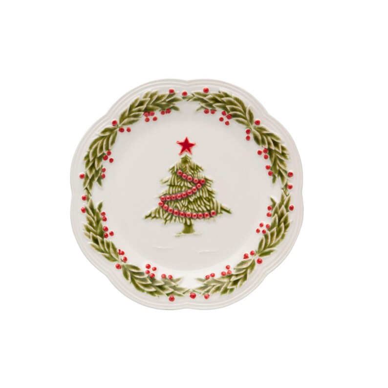 Op de afbeelding: Een witte keramische plaat met een geschulpte rand, met een groen kerstboomontwerp met rode kralenketting en een rode ster. De plaat is omcirkeld door een groene krans met rode bessen, perfect voor de feestdagen.