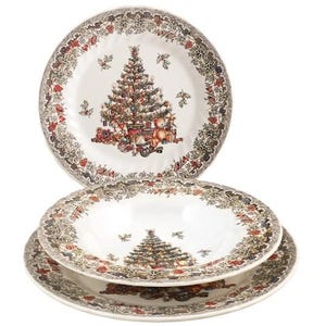 Op de afbeelding: Een set van drie witte keramische borden met een centrale afbeelding van een versierde kerstboom omringd door speelgoed en cadeaus, met een brede rand van hulstbladeren, rode bessen en dennenappels als decoratie.